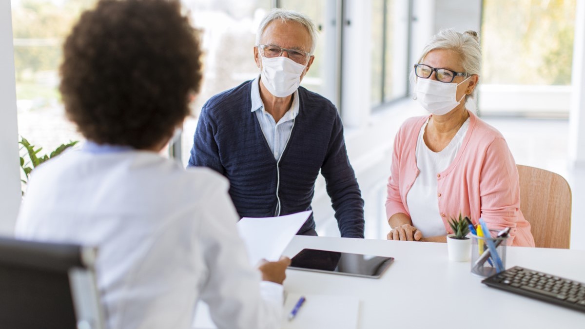 A man and woman talking to a doctor
