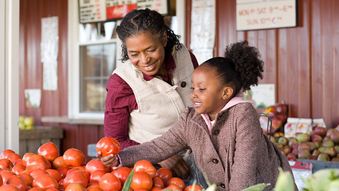 — title missing — Mother and daughter choosing vegetables at a farmer's market